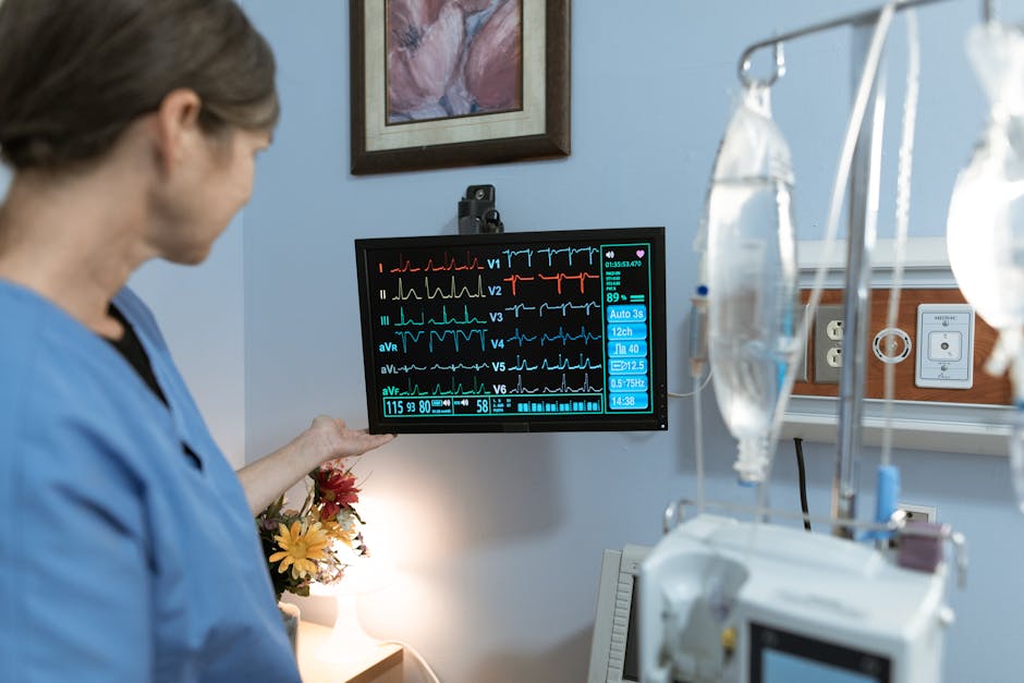 Nurse examining medical monitor displaying vital signs
