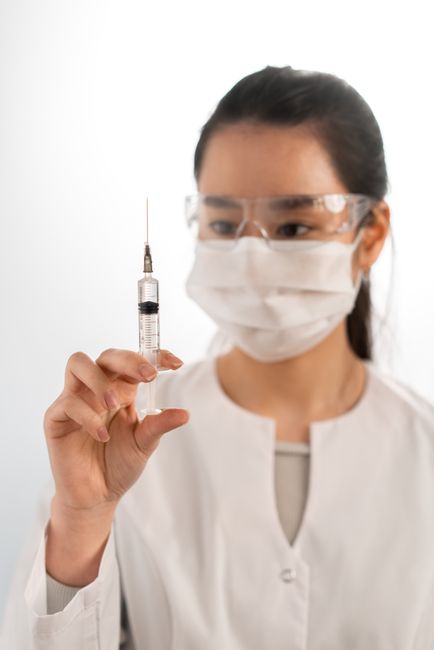 Asian doctor with syringe for treatment